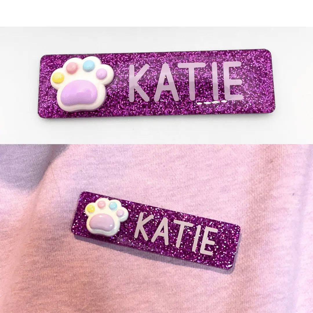 a pair of name tags with a dog paw on them