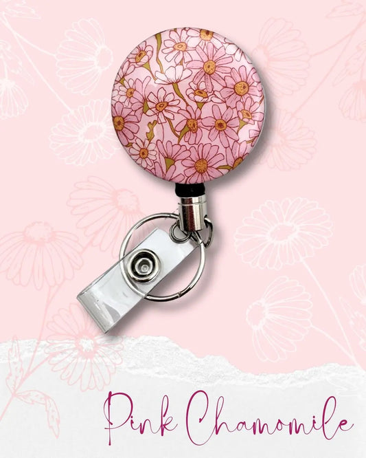 Pink Chamomile Floral Pattern on a heavy duty badge reel for identification cards, keys and more. Built to last. Background is light pink with semi transparent chamomile flowers in white and pink. An overall soft aesthetic.