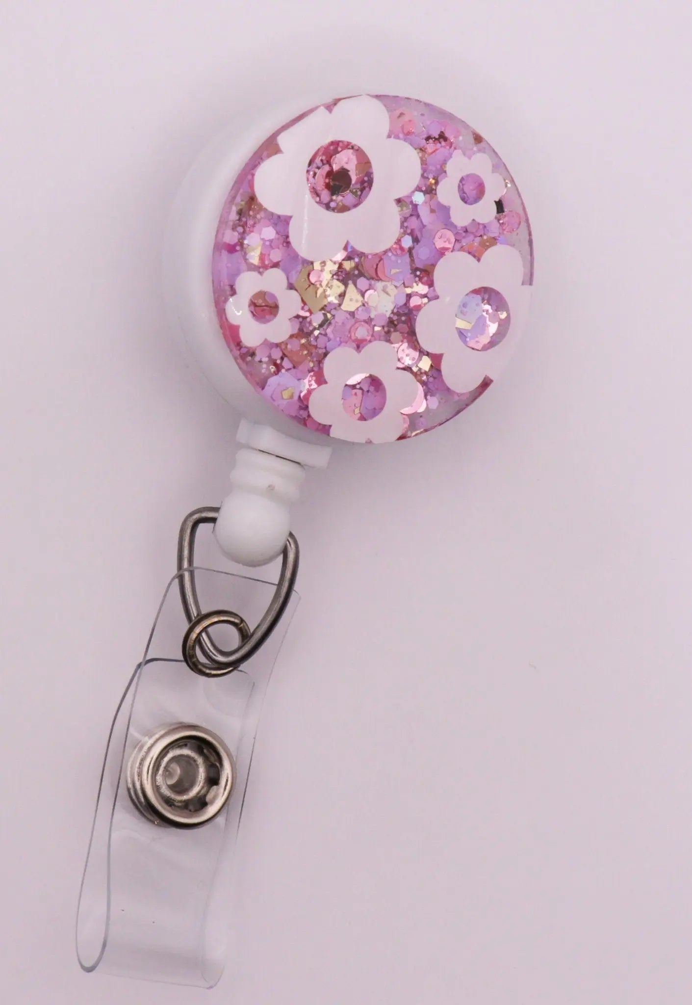 White Daisy Badge Reel with Pink Sparkle Background.