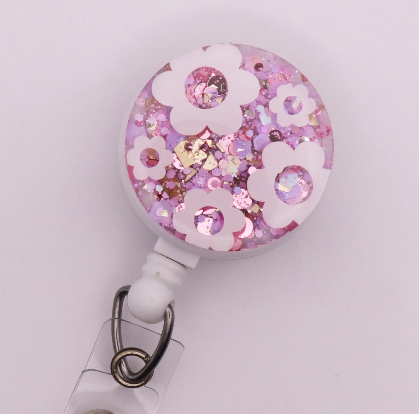 White Daisy Badge Reel with Pink Sparkle Background.