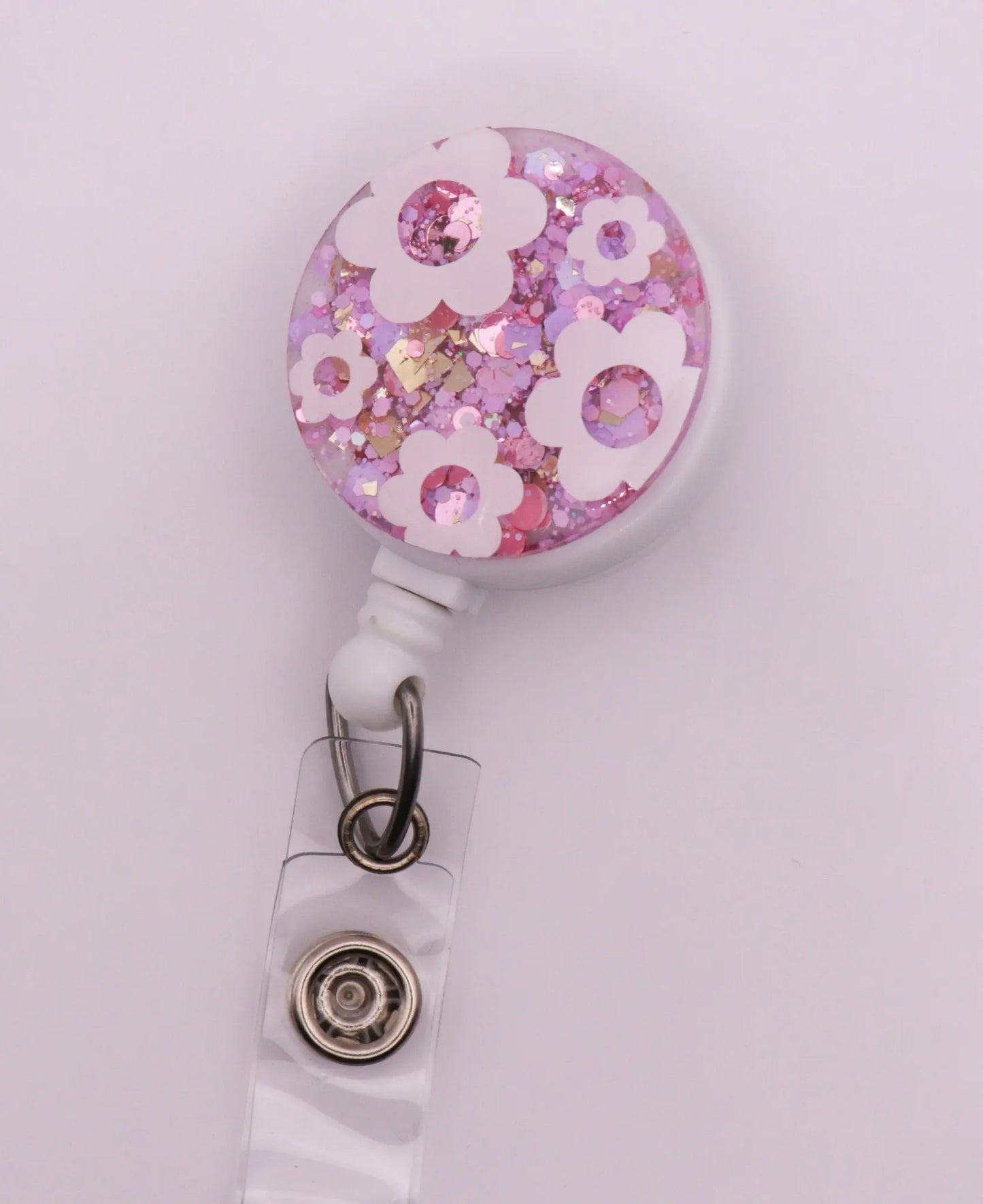 White Daisy Badge Reel with Pink Sparkle Background.