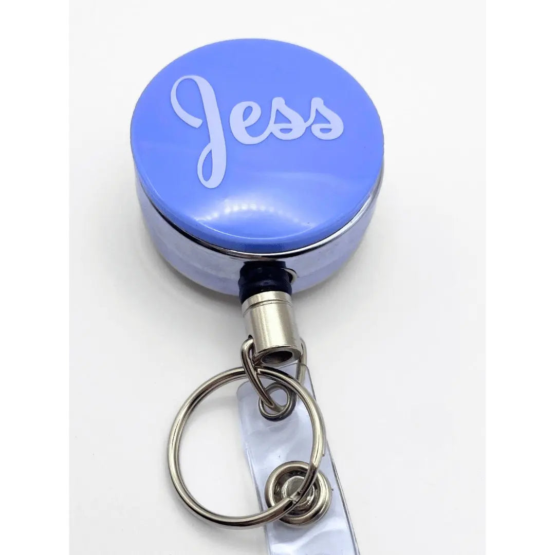 a blue and white key chain with the word jesus on it