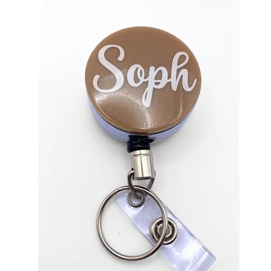 a brown and white badge with the word soph on it