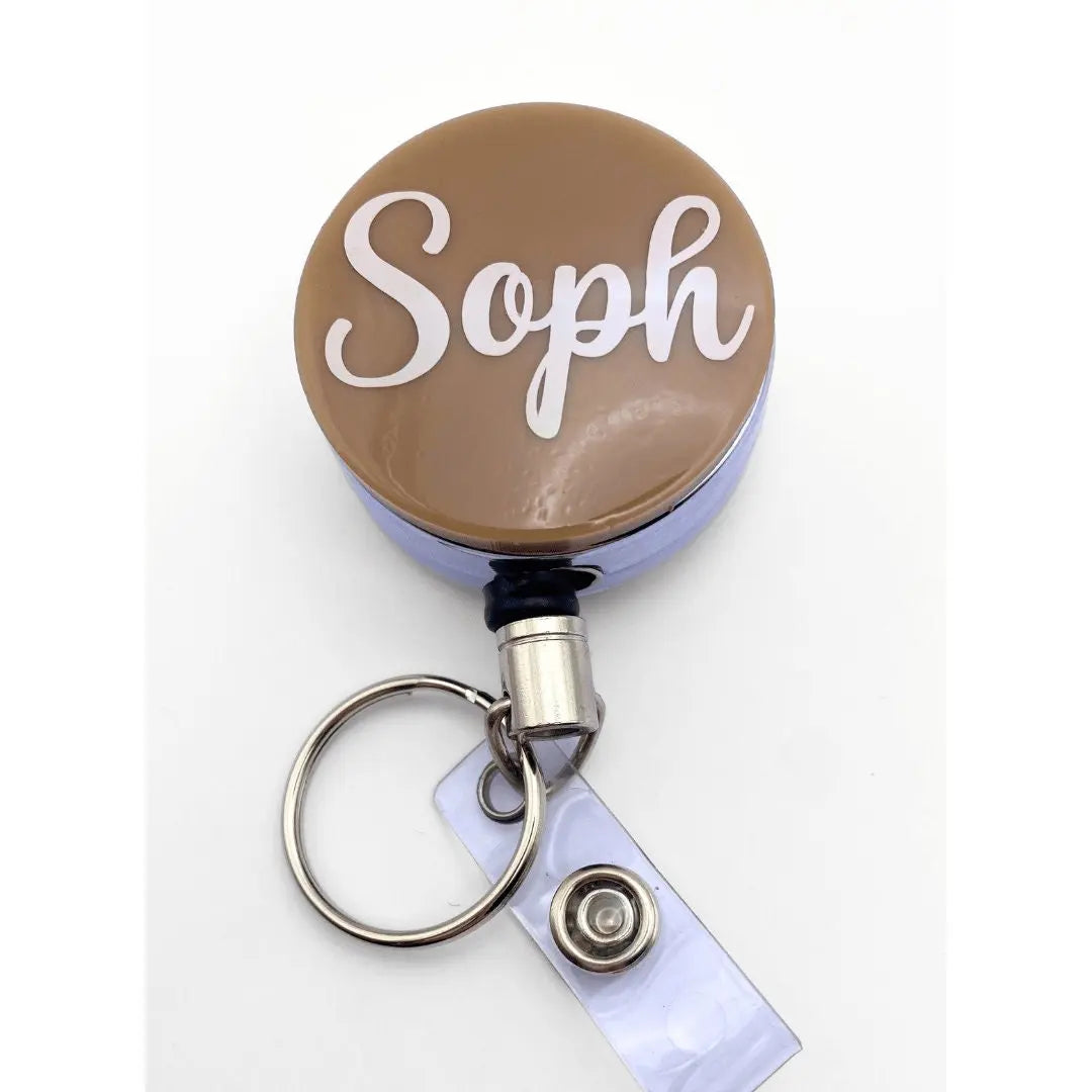 a brown and white badge with the word soph on it
