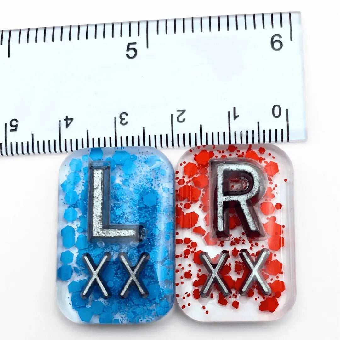 a ruler is next to two magnets with letters on them