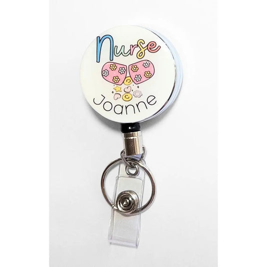 Heavy duty nursing badge reel with happy pill spilling out flowers, hearts, stars and smiles and the space for your name below in black writing.
