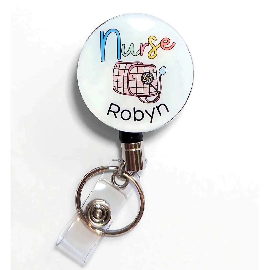 Heavy duty badge reel for Nurses with a pink and white sphygmomanometer and custom name underneath.
