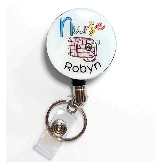 Heavy duty badge reel for Nurses with a pink and white sphygmomanometer and custom name underneath.